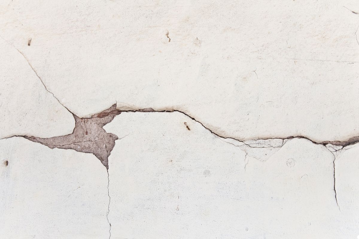 A close-up of a wall showing a prominent crack running vertically through its surface.